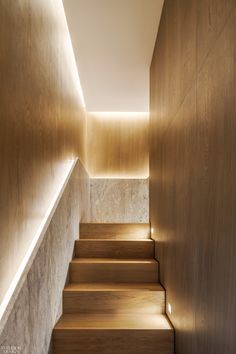 the stairs are lined with wooden planks and lit up by lights on either side