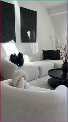 a living room with white furniture and black accents