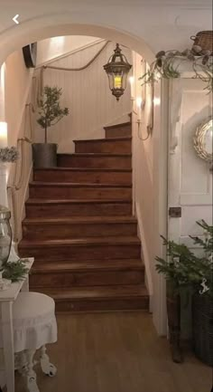 an entry way with stairs and potted plants