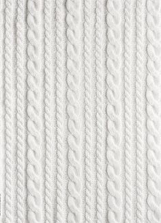 white knitted fabric textured with lines and braids, close - up photo