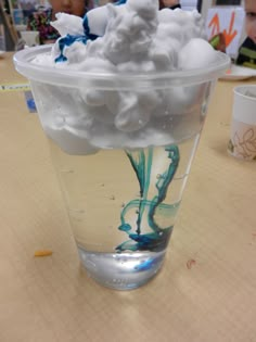 a glass filled with whipped cream on top of a wooden table