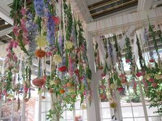 flowers are hanging from the ceiling in a room with white walls and windows, along with an instagram tweet