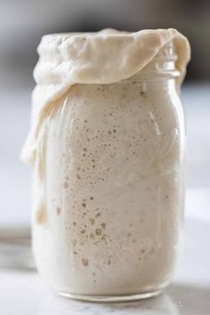 a glass jar filled with liquid sitting on top of a table