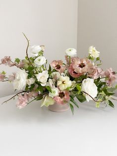 a vase filled with lots of white and pink flowers