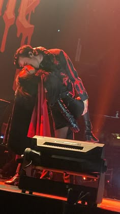 a man standing on top of a stage next to a keyboard