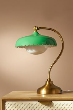 a green lamp sitting on top of a wooden table