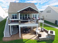 an aerial view of a house with deck, patio and fire pit in the yard