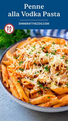 penne alla vodka with parmesan cheese and parsley on top in a bowl