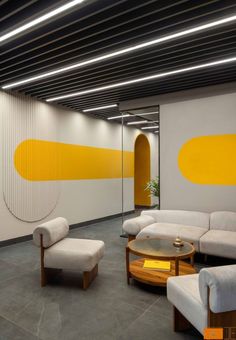 a room with couches, tables and chairs in it that has yellow circles painted on the wall