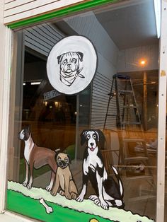 two dogs sitting in front of a store window