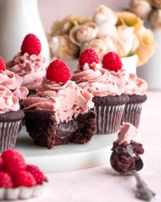 chocolate raspberry cupcakes with pink frosting and raspberries on top