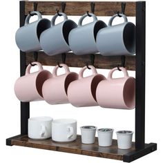 four cups are hanging on a rack with mugs