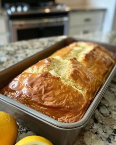 a loaf of bread sitting on top of a counter next to lemons