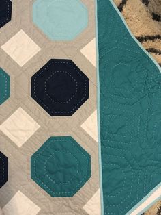 a blue and white quilted blanket with hexagons on it's sides