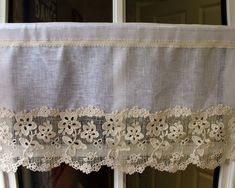 an image of a window curtain with lace on the edge and flowers in the middle