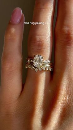 a woman's hand with a wedding ring on her finger and an engagement band