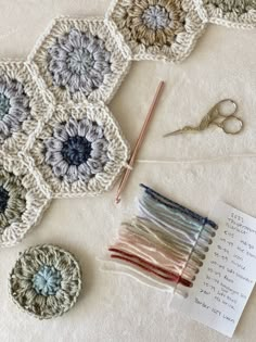 there are crocheted grannys and scissors on the table