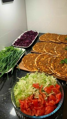 several different types of food are displayed on the counter in front of plates and pans