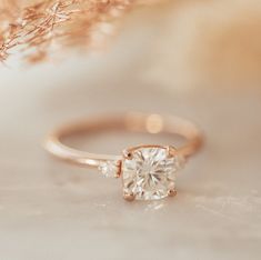 a close up view of a ring with a diamond on the top and side stones in the middle