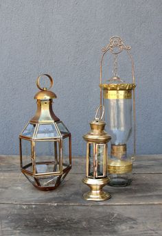 two brass lanterns sitting on top of a wooden table