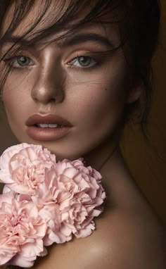 a woman with flowers in her hair and makeup is posing for the camera, she has long brown hair and blue eyes