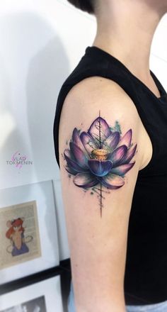 a woman's arm with a watercolor lotus tattoo on the left side of her arm