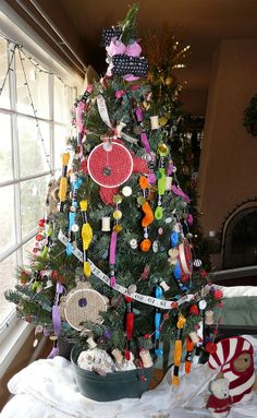 a decorated christmas tree in a living room with lots of ribbons and decorations on it