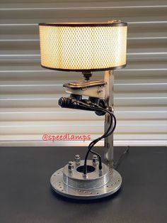 a lamp that is sitting on top of a table in front of a metal object