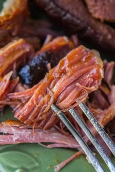 a close up of a fork with meat on it