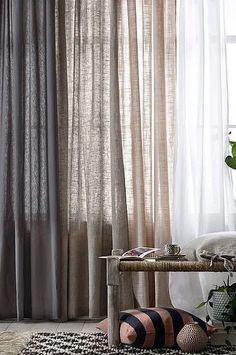 a living room with curtains and rugs on the floor