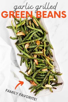 green beans with almonds in a white dish on a marble countertop, ready to be eaten