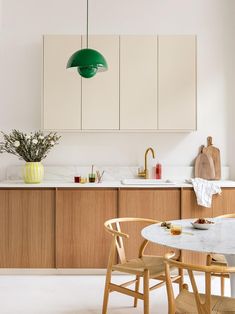 the kitchen is clean and ready to be used for dinner or lunchtime, with green pendant lights hanging from the ceiling