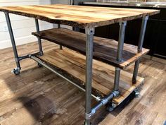 a kitchen island made out of metal pipes and wood planks with wheels on each side