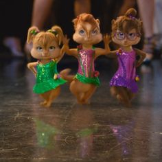 three little chipmuns dressed in green and pink dresses standing next to each other