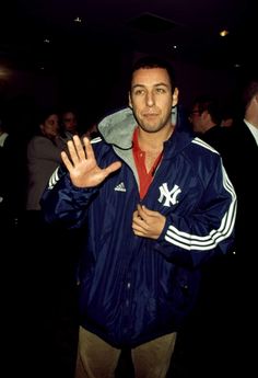 a man standing in front of a crowd holding his hand up to the camera and making a stop sign