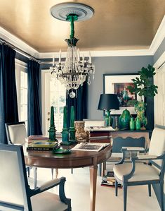 a dining room table with chairs and a chandelier hanging from it's ceiling