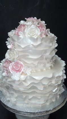 a three tiered cake with pink and white flowers on it's top layer