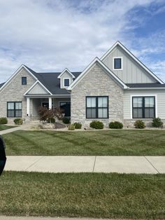 a large house sitting on the side of a road next to a lush green field