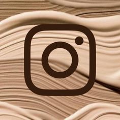 the instagram logo is shown on top of a wooden surface with wavy lines in brown