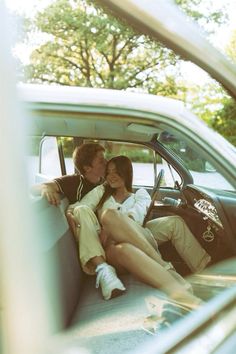 two people sitting in the back seat of a car