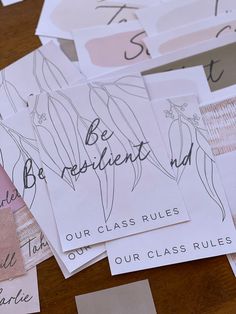 many different types of paper with writing on them sitting on top of a wooden table