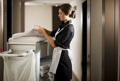 a woman standing in front of a stack of folded towels on top of a table