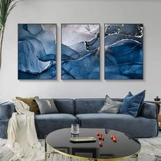 three paintings are hanging on the wall in a living room