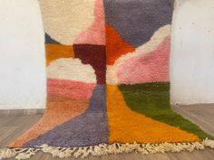 a multicolored rug with fringes on the floor