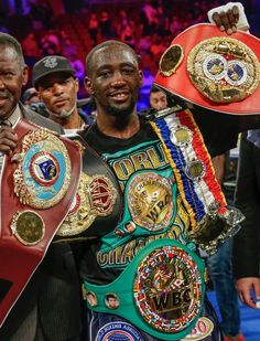 two men standing next to each other holding up their boxing belts in front of them