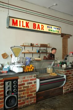 there is a man behind the bar at milk bar, which serves breakfast and desserts