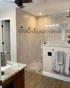 a bathroom with a walk in shower next to a sink and toilet paper dispenser