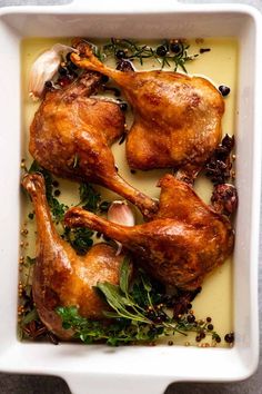 roasted chicken with herbs and garlic in a white casserole dish