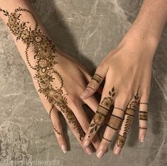 two hands with henna tattoos on them