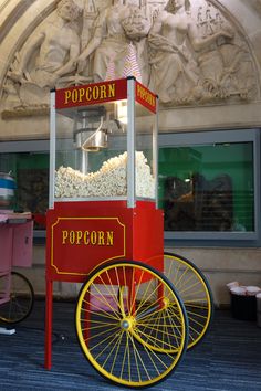 an old fashioned popcorn machine in front of a building